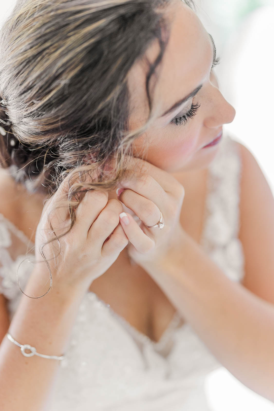 gorgeous close-up of bride getting ready putting on earrings before wedding