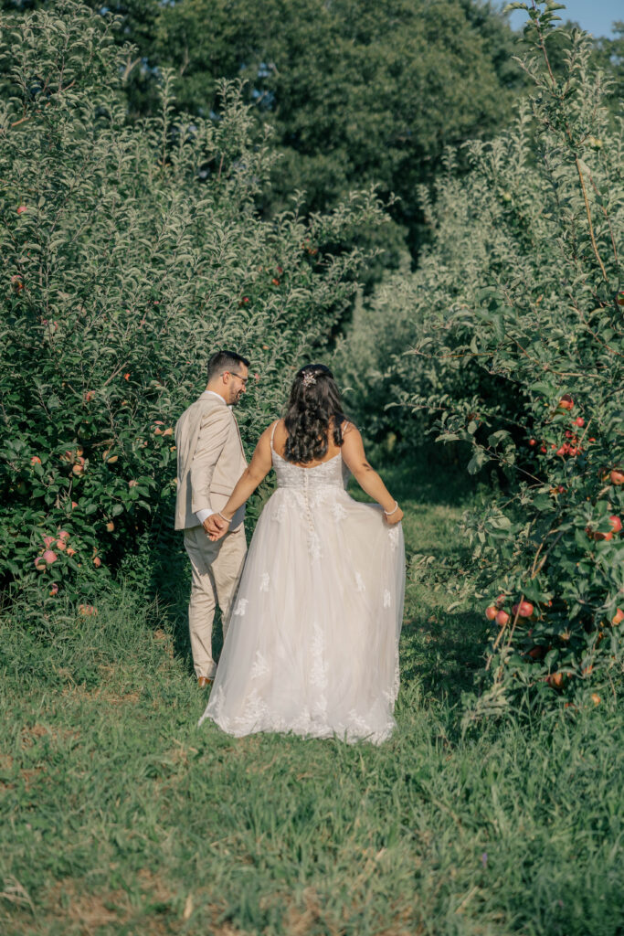 a young couple having a private moment in an orchard after their intimate wedding ceremony