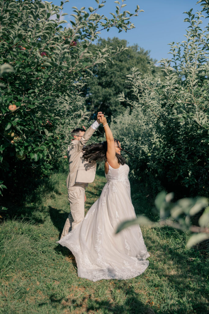 a young couple sharing a private dance in an orchard after their intimate wedding ceremony