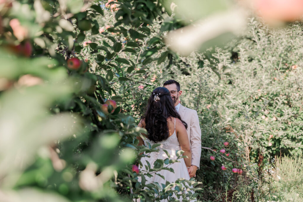 Bride and groom having quiet, heartfelt vow exchange during intimate orchard wedding