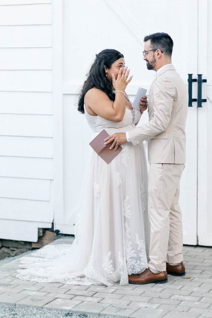 Bride and groom having quiet, heartfelt, emotional vow exchange during intimate orchard wedding