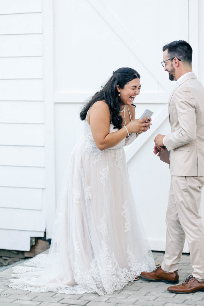 Bride and groom having quiet, heartfelt vow exchange with laughter during intimate orchard wedding