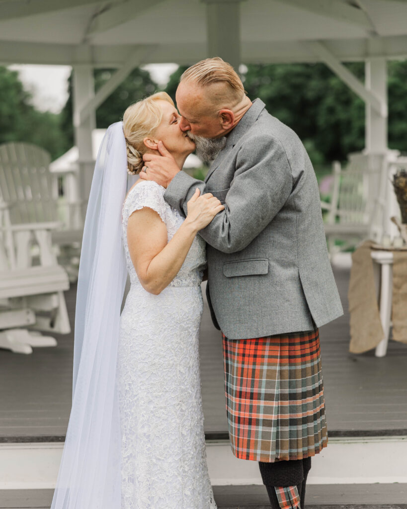 bride and groom sharing a first kiss during an intimate wedding ceremony at a farm in Rhode Island