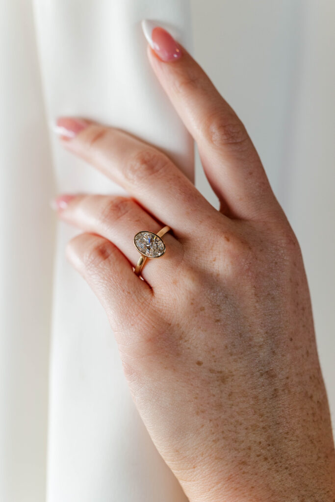 Close-up picture of bride's engagement ring as she straightens her veil before her wedding ceremony