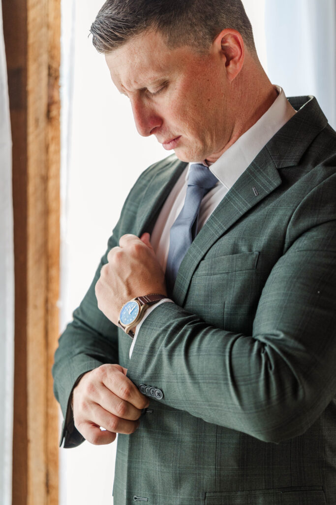 Groom getting ready before his intimate wedding ceremony at an orchard in New England
